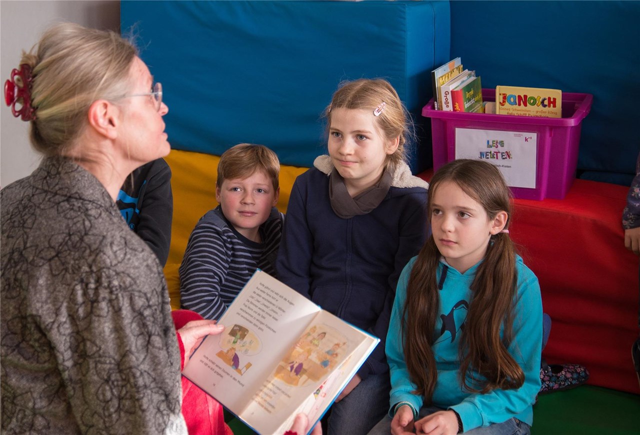 Vier Mädchen gucken in ein Buch